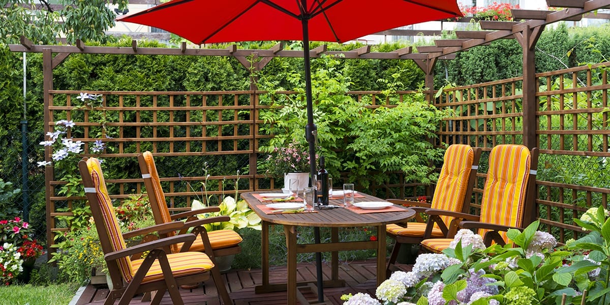 live-outside-outdoor-room-hedge-trellis-patio-umbrella