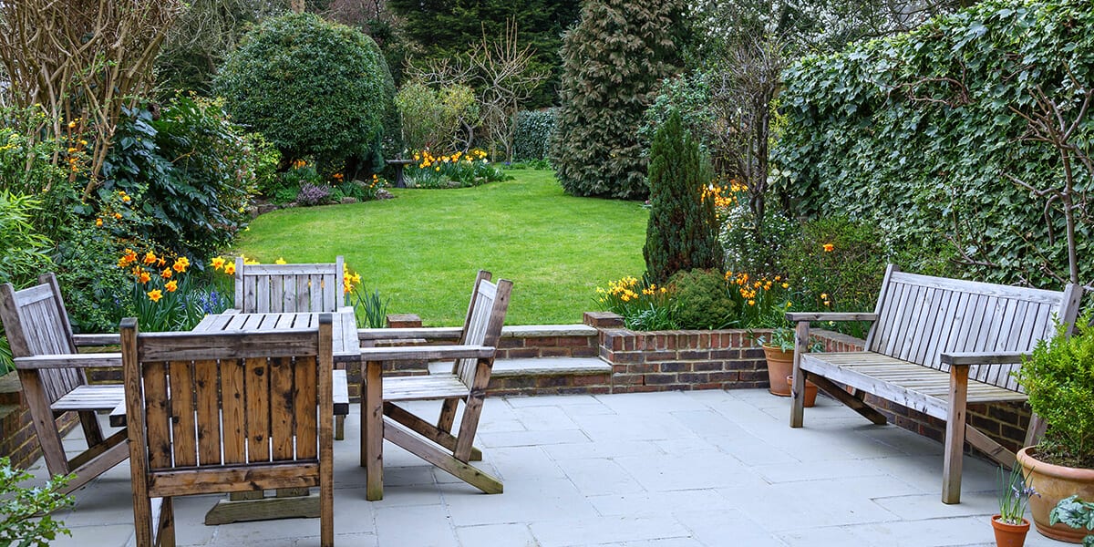 platt hill nursery fixes to common yard issues healthy garden with daffodils and patio furniture