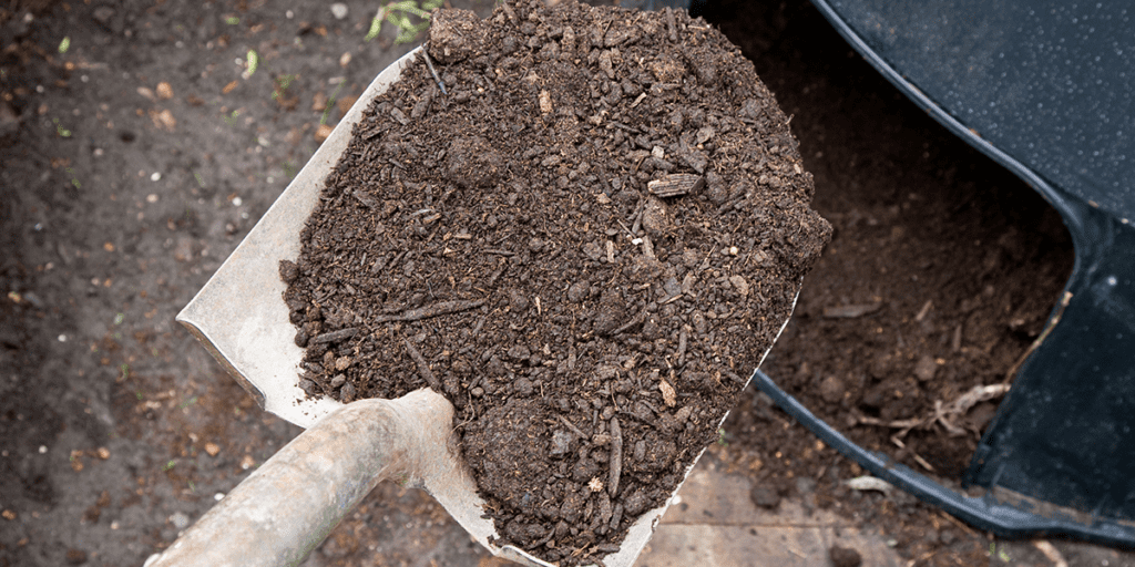 Platt Hill Nursery -how to start composting in Illinois - shoveling compost out of bin