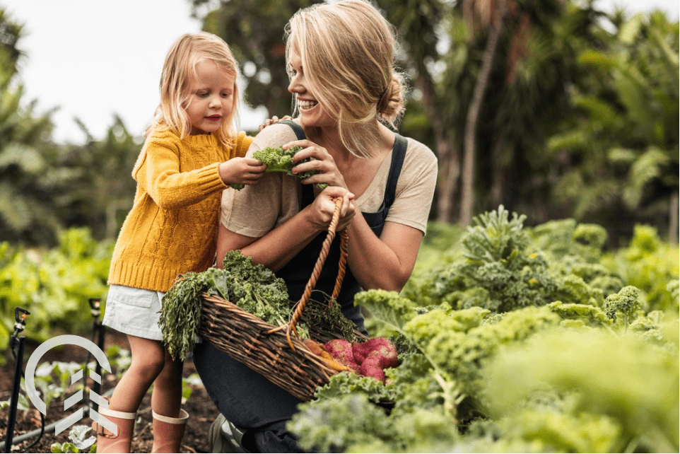 mom and daughter harvesting fall vegetables from their garden